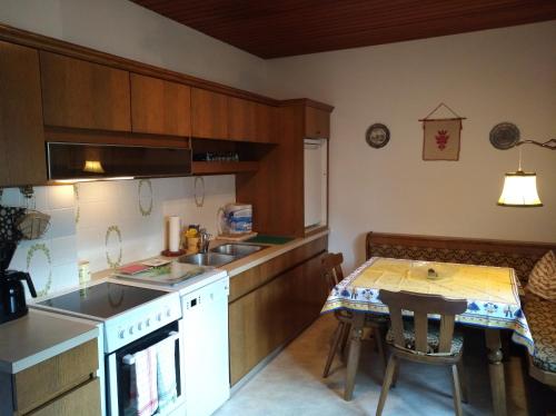a kitchen with a sink and a table with a counter at Haus Friedburg in Velden am Wörthersee