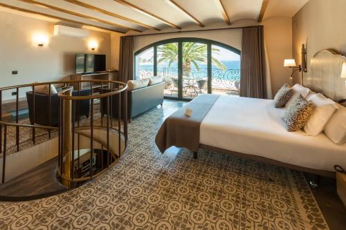 トッサ・デ・マールにあるホテル ディアナの大きなベッドとバルコニーが備わるホテルルームです。