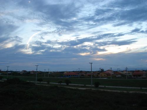 a cloudy sky with a road and houses in the background at Villaggio dos Ventos in Arraial do Cabo