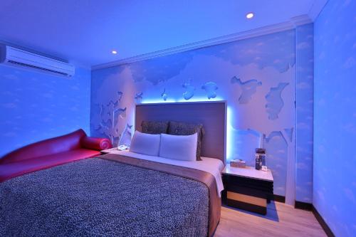 a bedroom with a large bed with a purple wall at Full Moon Motel in Shulin