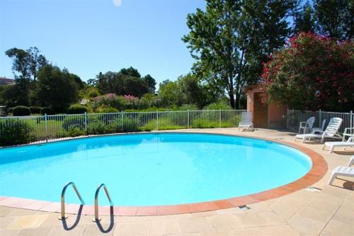 une grande piscine avec des chaises autour dans l'établissement Complesso Residenziale Marina di Pinarello, à Pinarellu