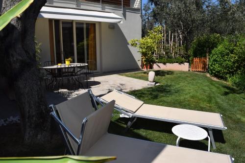 a patio with a table and chairs in a yard at "CASABANA" - relax tutto l'anno - giardino - piscina Top in Malcesine