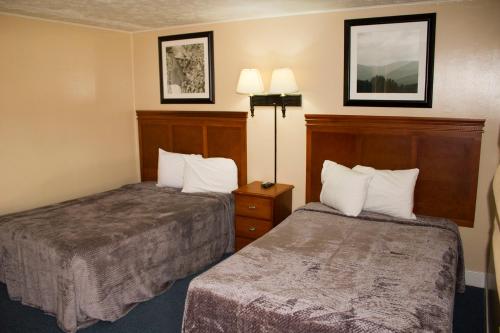 a hotel room with two beds and two lamps at Budget Inn in Luray