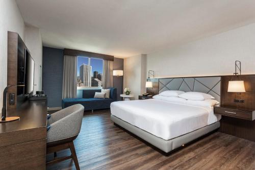 a bedroom with a large white bed and a couch at Hyatt Regency Rochester in Rochester