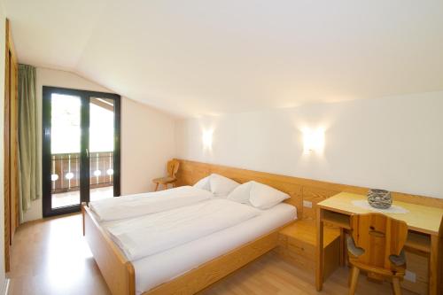 カルダーロにあるGarni Saltneregg Ferienwohnungenのベッドルーム1室(ベッド1台、デスク、窓付)