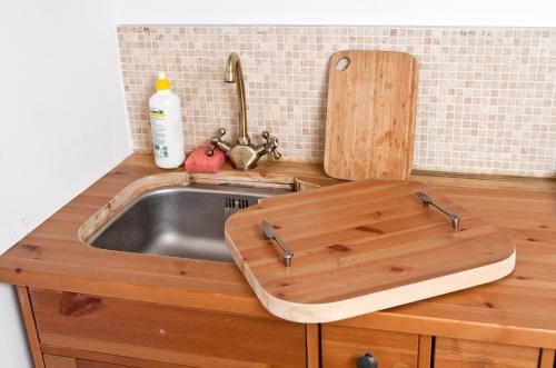 a kitchen with a sink and a wooden cutting board at Podlesice 38 in Kroczyce