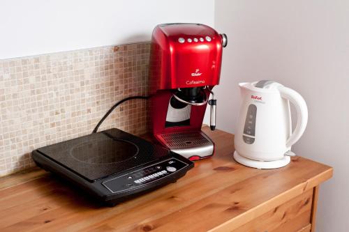 a red coffee maker on a wooden counter with a coffeemaker at Podlesice 38 in Kroczyce