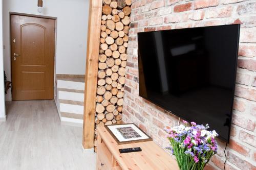 a brick fireplace with a flat screen tv at Podlesice 38 in Kroczyce