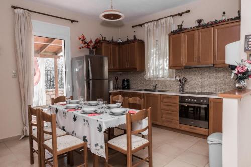 eine Küche mit einem Tisch mit Stühlen und einem Kühlschrank in der Unterkunft Aloni Home in Petrokefálion