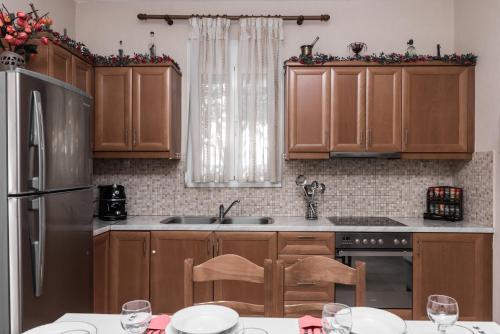 eine Küche mit Holzschränken und einem Tisch mit Weingläsern in der Unterkunft Aloni Home in Petrokefálion