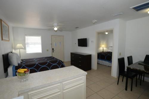 a bedroom with a bed and a kitchen with a desk at Port Isla Inn in Port Isabel