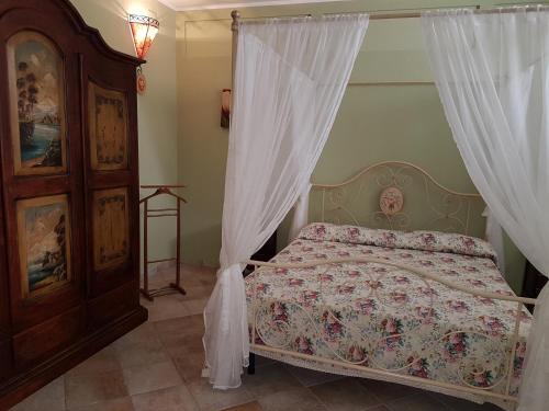 a bedroom with a bed with a canopy and curtains at B&B Verardo in Specchia