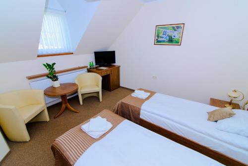 a hotel room with two beds and a desk at Noclegi Sobańskich in Gniezno