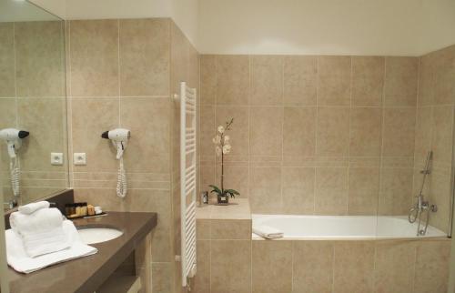 een badkamer met een bad, een wastafel en een douche bij Perla Rossa in LʼÎle-Rousse
