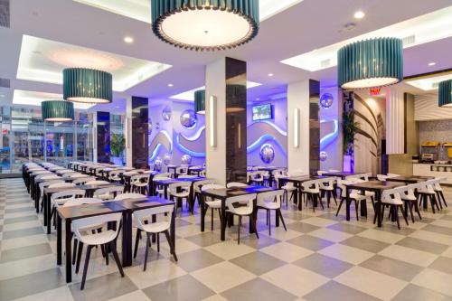 a restaurant with tables and chairs and purple lighting at Riu Plaza New York Times Square in New York