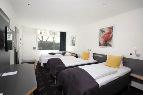 En eller flere senge i et værelse på Hotel Hedegaarden