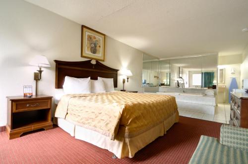 a hotel room with a bed and a bath tub at Key West Inn - Newport News in Newport News