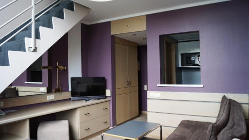 a living room with purple walls and a staircase at Hotel Olivier in Luxembourg