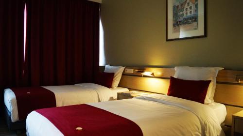 a hotel room with two beds and a window at Hotel Olivier in Luxembourg
