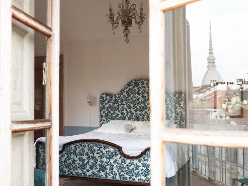 Schlafzimmer mit einem Bett und einem Fenster in der Unterkunft Colazione in Piazza Castello in Turin