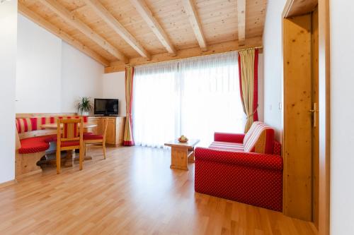 a living room with red furniture and a table at Hotel Jager Hans in San Martino