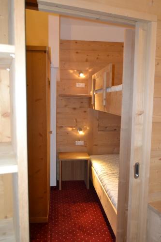 a small room with a bunk bed and a bench at Häuslerhof in Maranza