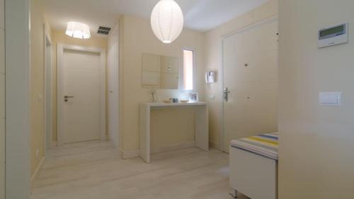 a white bathroom with a sink and a white door at Tres Castelos in Portimão