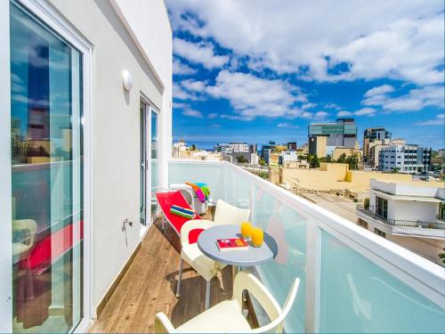 d'un balcon avec une table et des chaises offrant une vue sur la ville. dans l'établissement Bayside Apartments, à San Ġiljan