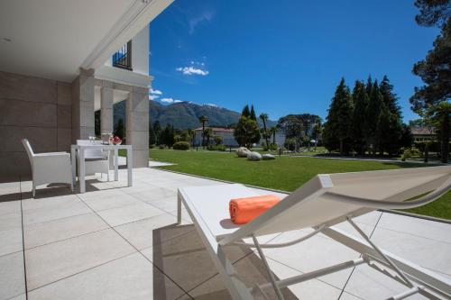 a patio with a white chair and a table at Delta Resort Apartments in Ascona