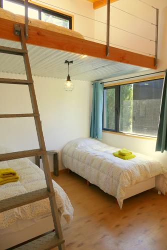 a bedroom with two bunk beds and a ladder at Casas Chaura in El Bolsón