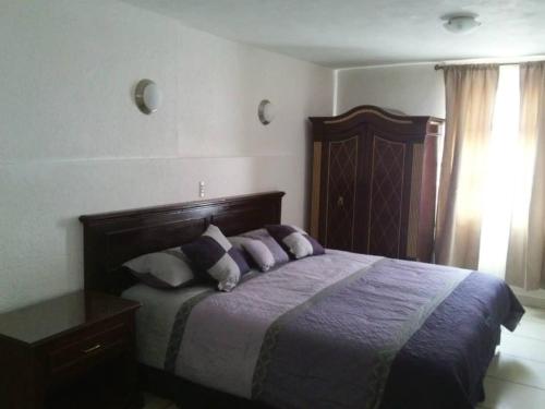 a bedroom with a bed with purple sheets and pillows at Hotel El Beso De Calixto in Guanajuato