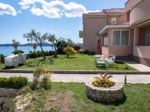 a house with a yard with a table and chairs at Apartments Nino 1 in Zadar