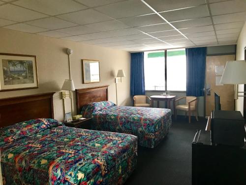 Habitación de hotel con 2 camas y mesa en Tides Inn en Ocean City