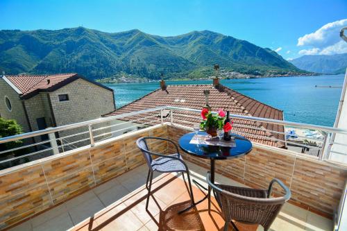 a balcony with a table and chairs and a view of the water at Apartment The Sea Coast in Kotor