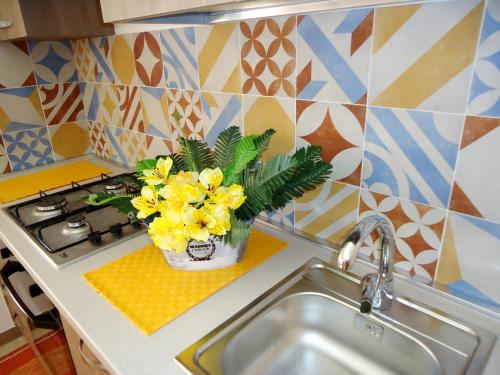 パチェーコにあるApartments Drago di Ferroの黄色い花瓶付き洗面台