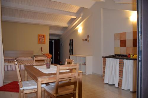 eine Küche und ein Esszimmer mit Tisch und Stühlen in der Unterkunft Le Case Di Bacco in Santa Venerina