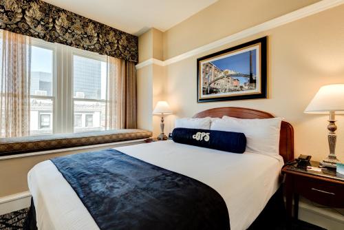 a hotel room with a bed and two windows at Gaslamp Plaza Suites in San Diego