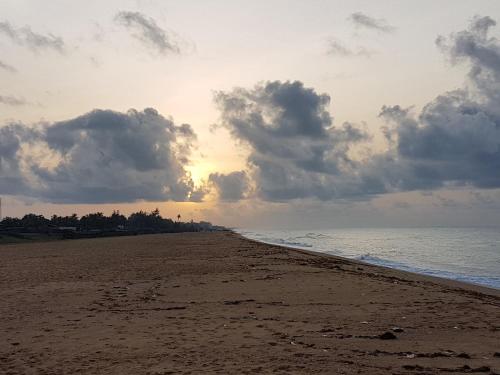 a beach with a cloudy sky and the ocean at Ramaya Auberge Espagnole in Grand-Popo