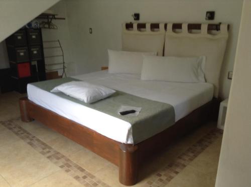a bedroom with a large bed with white sheets at Villas de Brisas in Cuernavaca