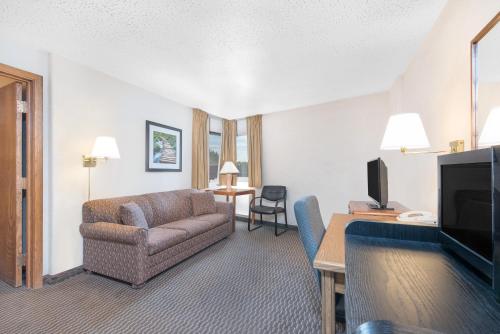 a living room with a couch and a television at Days Inn by Wyndham West Rapid City in Rapid City