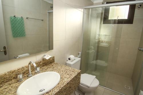 a bathroom with a sink and a toilet and a shower at Hotel San Lucas in Gramado