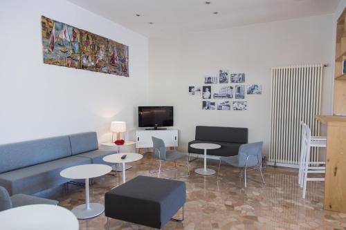 a living room with a couch and tables and a tv at Hotel Turismo Europa in Casal Borsetti