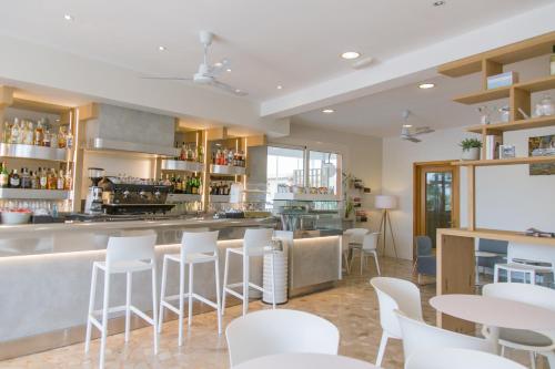 ein Restaurant mit weißen Stühlen und einer Bar in der Unterkunft Hotel Turismo Europa in Casal Borsetti