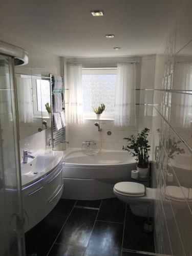 ein Badezimmer mit einer Badewanne, einem WC und einem Waschbecken in der Unterkunft 5 Sterne Ferienwohnung Cattaleya in Emden