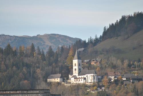a large white building with a church on a hill at Apartment Fewo Irdning Pichlarn in Aigen im Ennstal