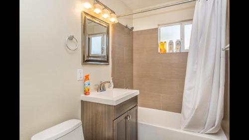 ein Badezimmer mit einem Waschbecken, einem WC und einem Spiegel in der Unterkunft Adorable House only a few miles from the Strip in Las Vegas