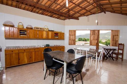 cocina y comedor con mesa y sillas en Pousada Recanto Verde, en Mucugê