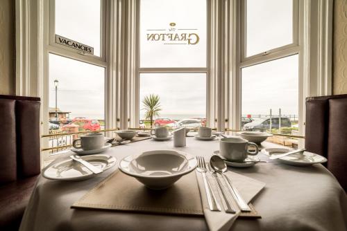 a dining room table with a view of the ocean at The Grafton Guest House in Llandudno
