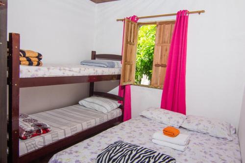 a room with two bunk beds and a window at Pousada Recanto Verde in Mucugê