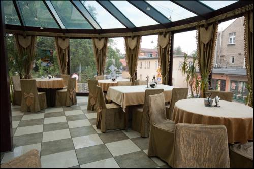 a restaurant with tables and chairs in a room at Hotel Maria Helena in Szczawno-Zdrój